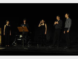 Fünf Personen auf einer Bühne in einem Halbkreis während einer musikalischen Darbietung