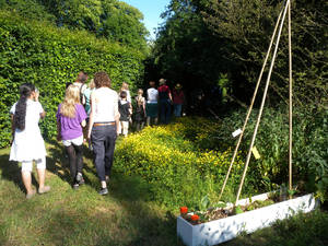 Eine Besuchergruppe macht sich auf den Weg in ein von Kindern und atelier le balto gestaltetes Triangel des Großen Gartens